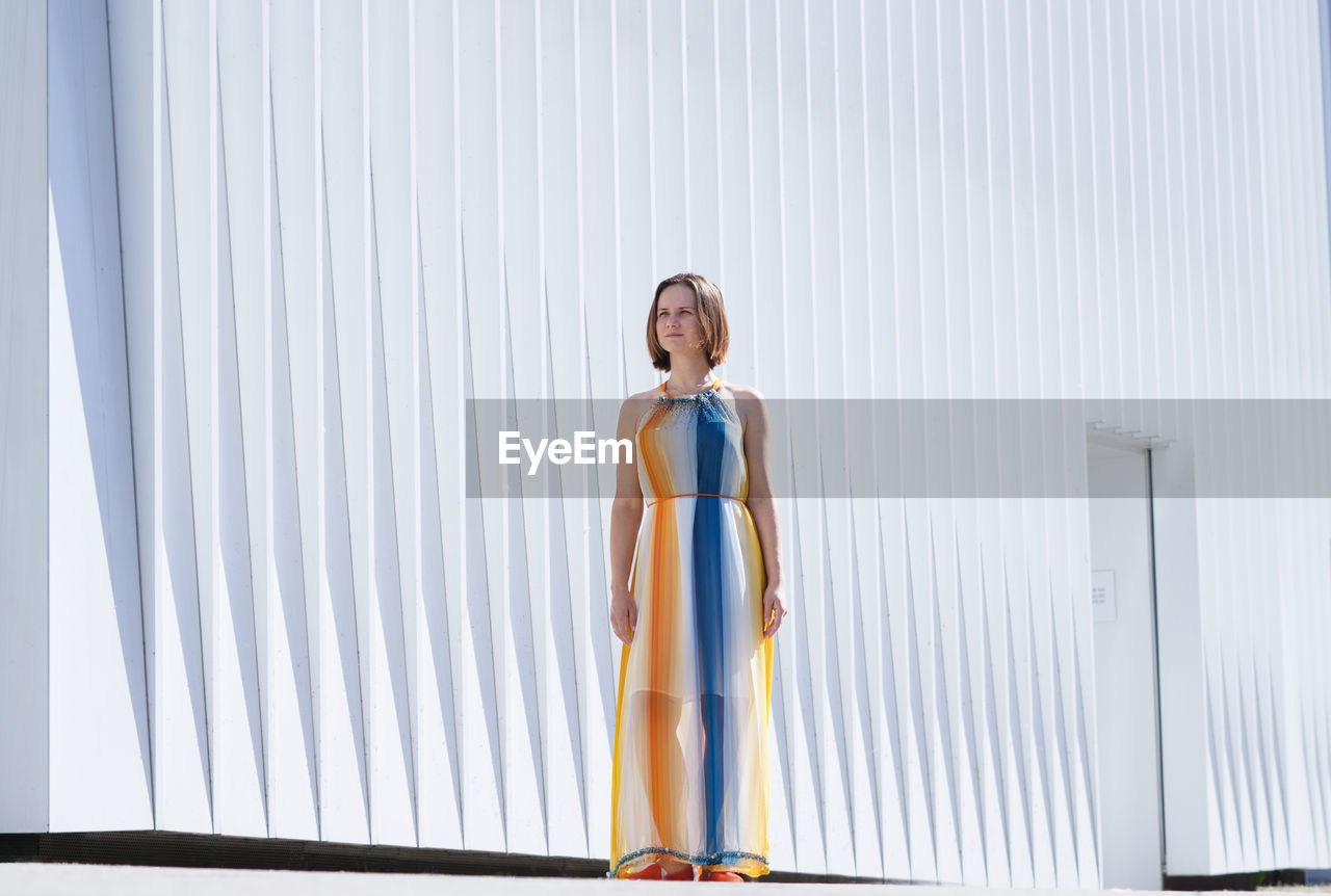 Full length of woman standing against wall outdoors