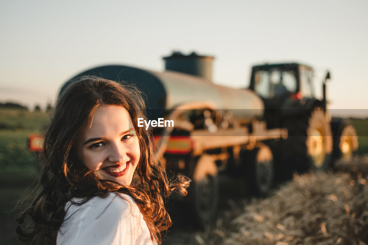 Portrait of beautiful woman in car against sky