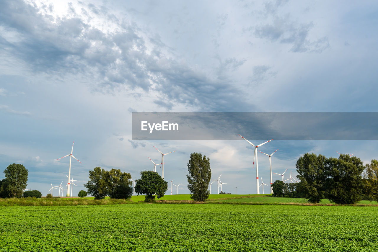 VIEW OF WINDMILL ON FIELD AGAINST CLOUDY SKY