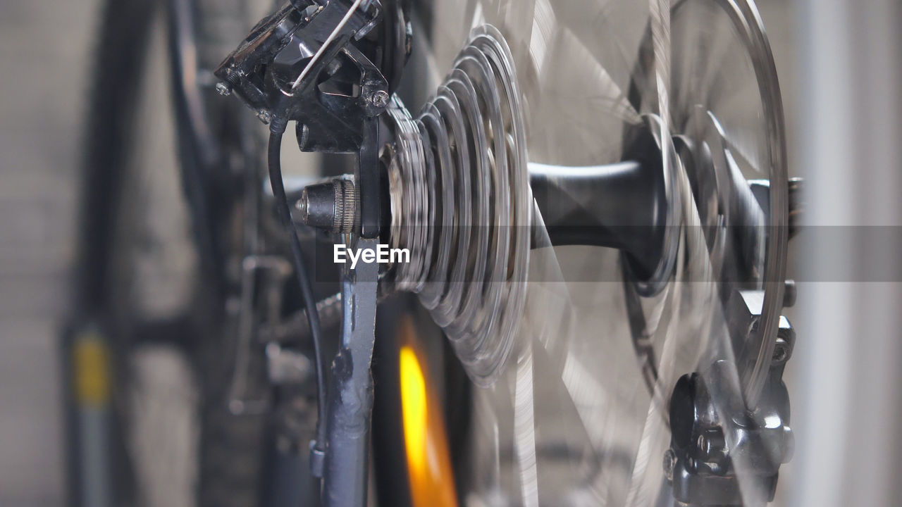 bicycle, close-up, no people, indoors, vehicle, selective focus, iron, wheel, metal, technology, industry, focus on foreground, hanging, business
