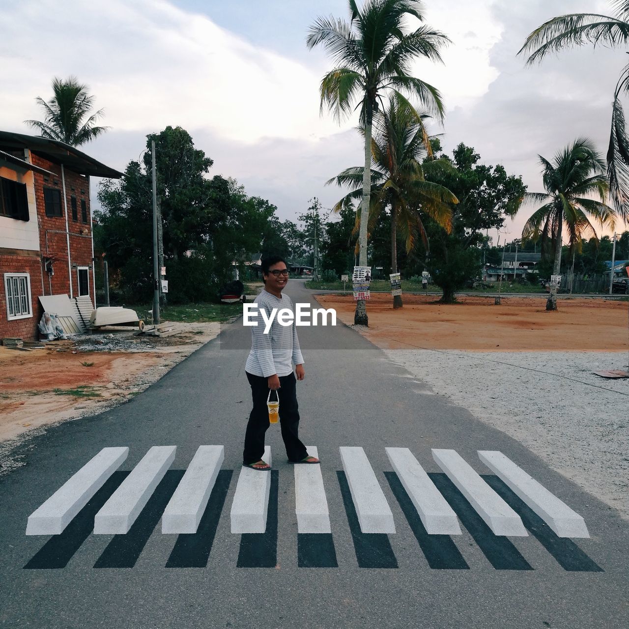 REAR VIEW OF A MAN WALKING ON STREET