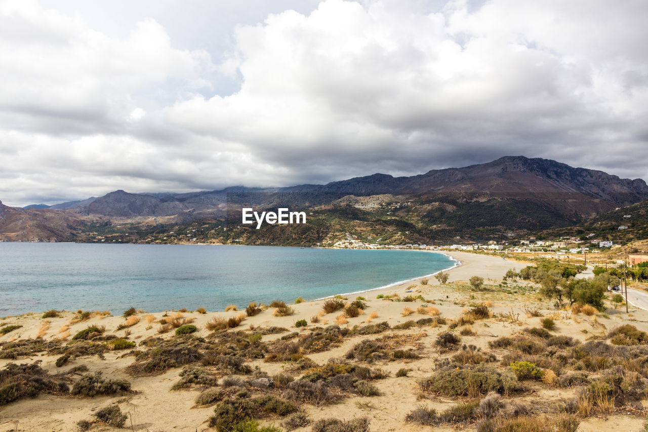 SCENIC VIEW OF SEA BY MOUNTAIN AGAINST SKY