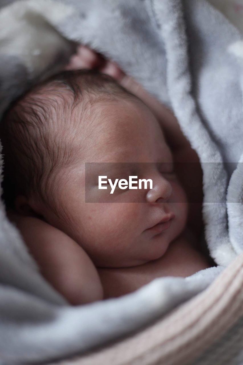 Close-up of baby sleeping on bed