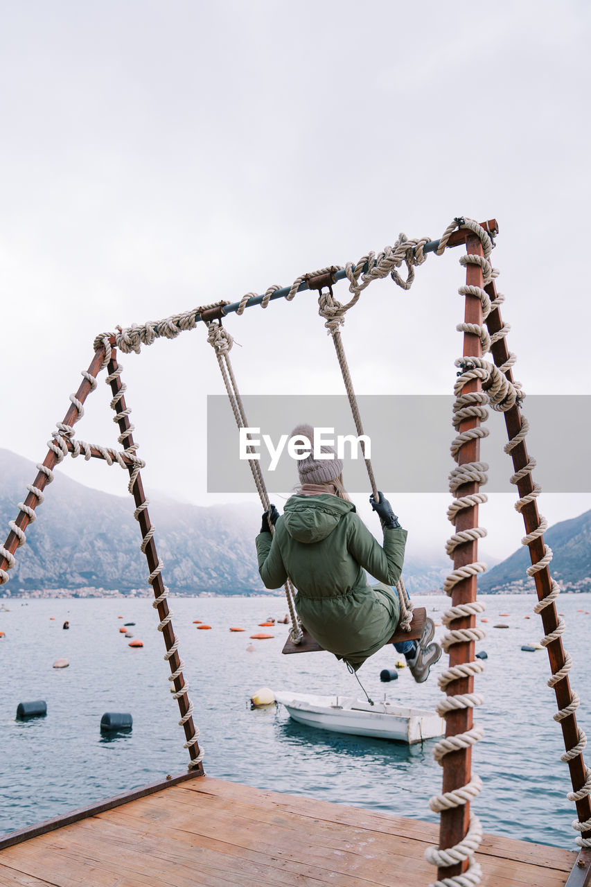 low angle view of man standing on rope against clear sky