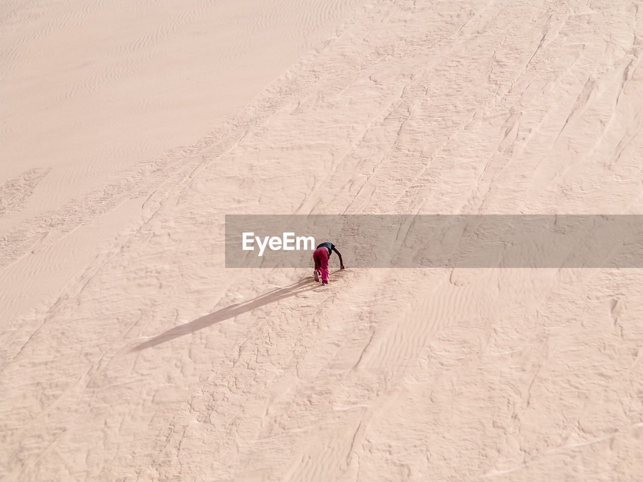 HIGH ANGLE VIEW OF PERSON SKIING ON SAND IN DESERT