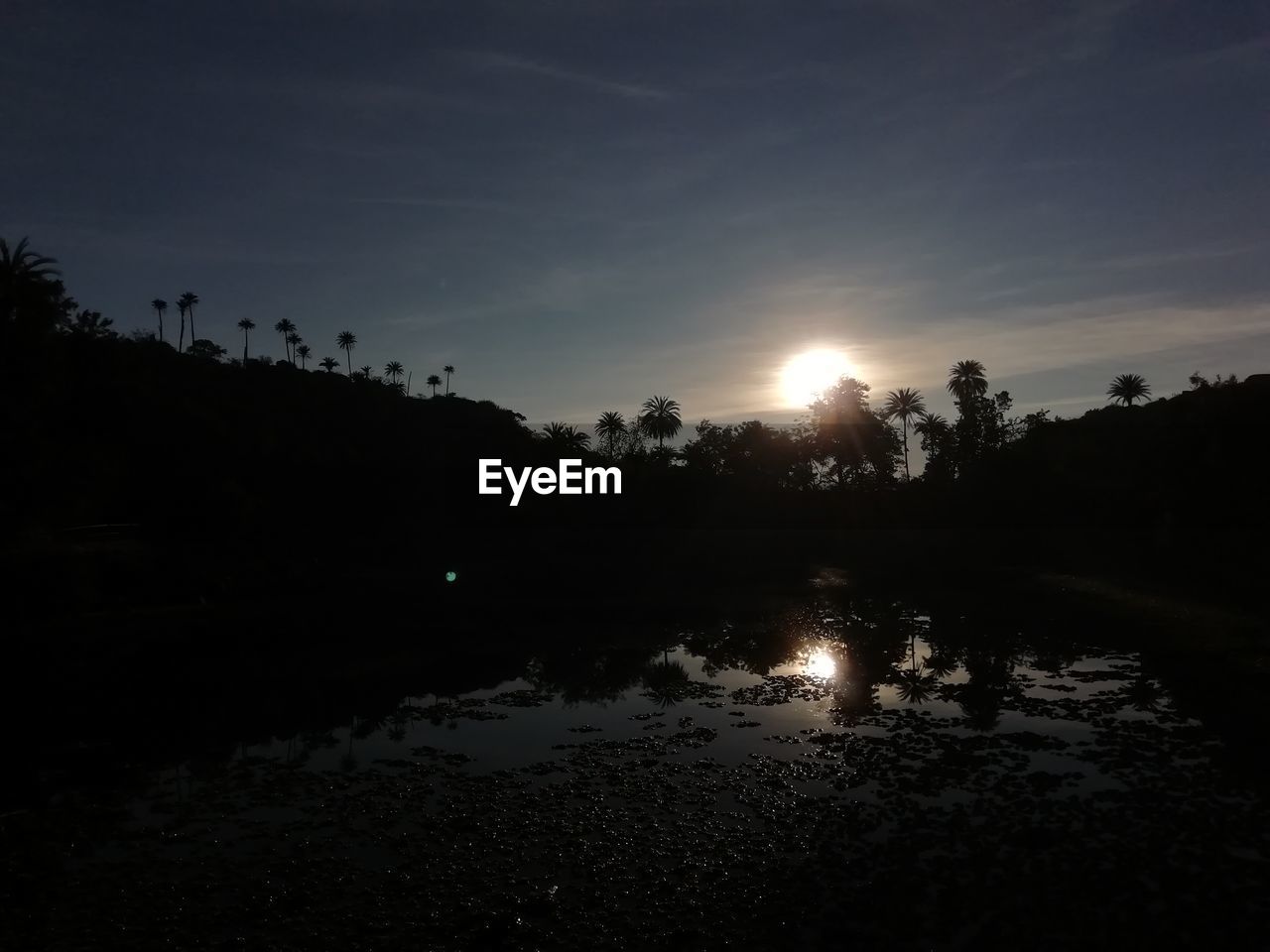 SCENIC VIEW OF LAKE AGAINST SKY AT SUNSET