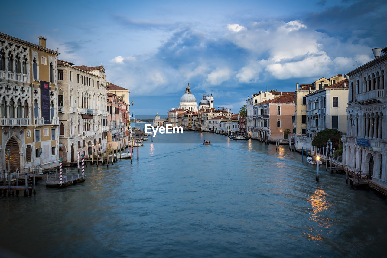 architecture, water, building exterior, travel destinations, nautical vessel, built structure, gondola, city, travel, transportation, sky, canal, tourism, mode of transportation, nature, cityscape, body of water, cloud, building, reflection, trip, vacation, bridge, waterway, holiday, gondolier, boat, craft, sea, vehicle, history, the past, place of worship, town, evening, lagoon, channel, outdoors, religion, old, waterfront, watercraft, bell tower, tourist, beauty in nature, idyllic, blue, romance, multi colored, residential district