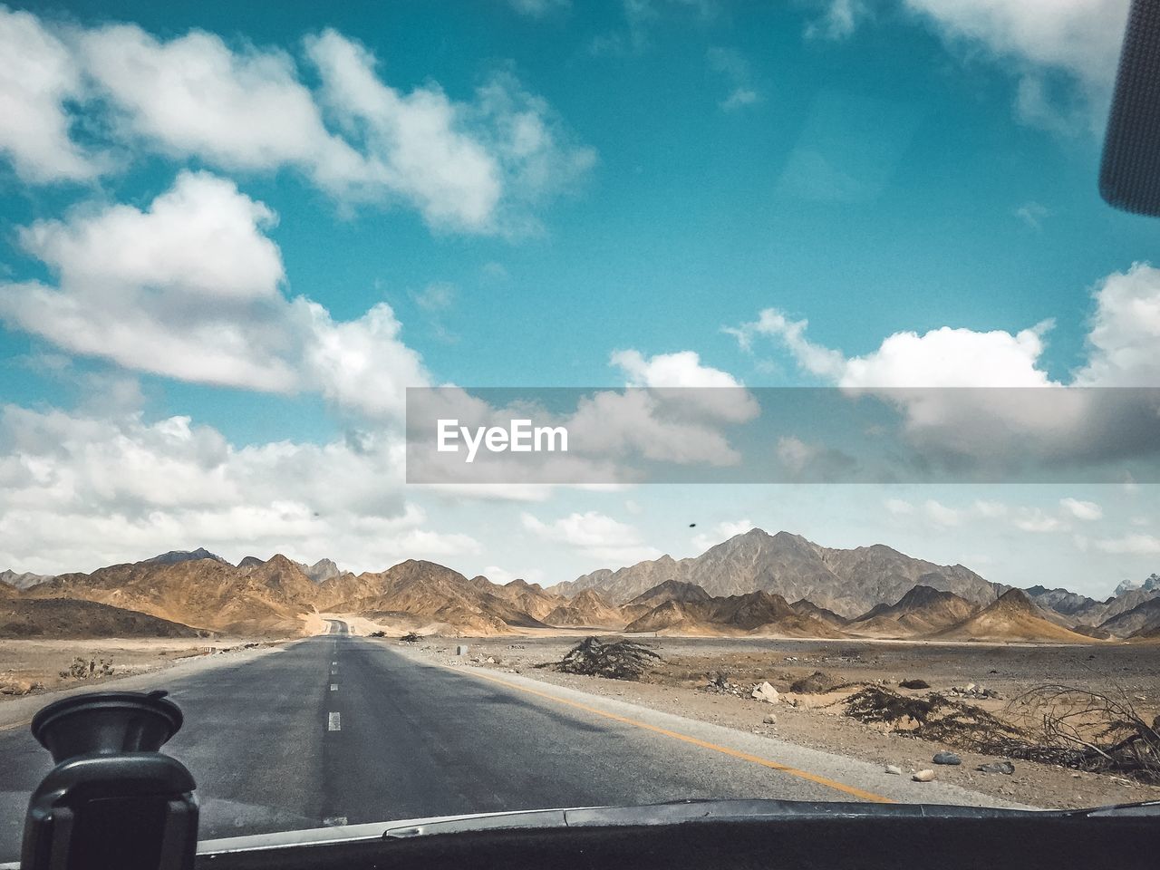 Road passing through desert against sky