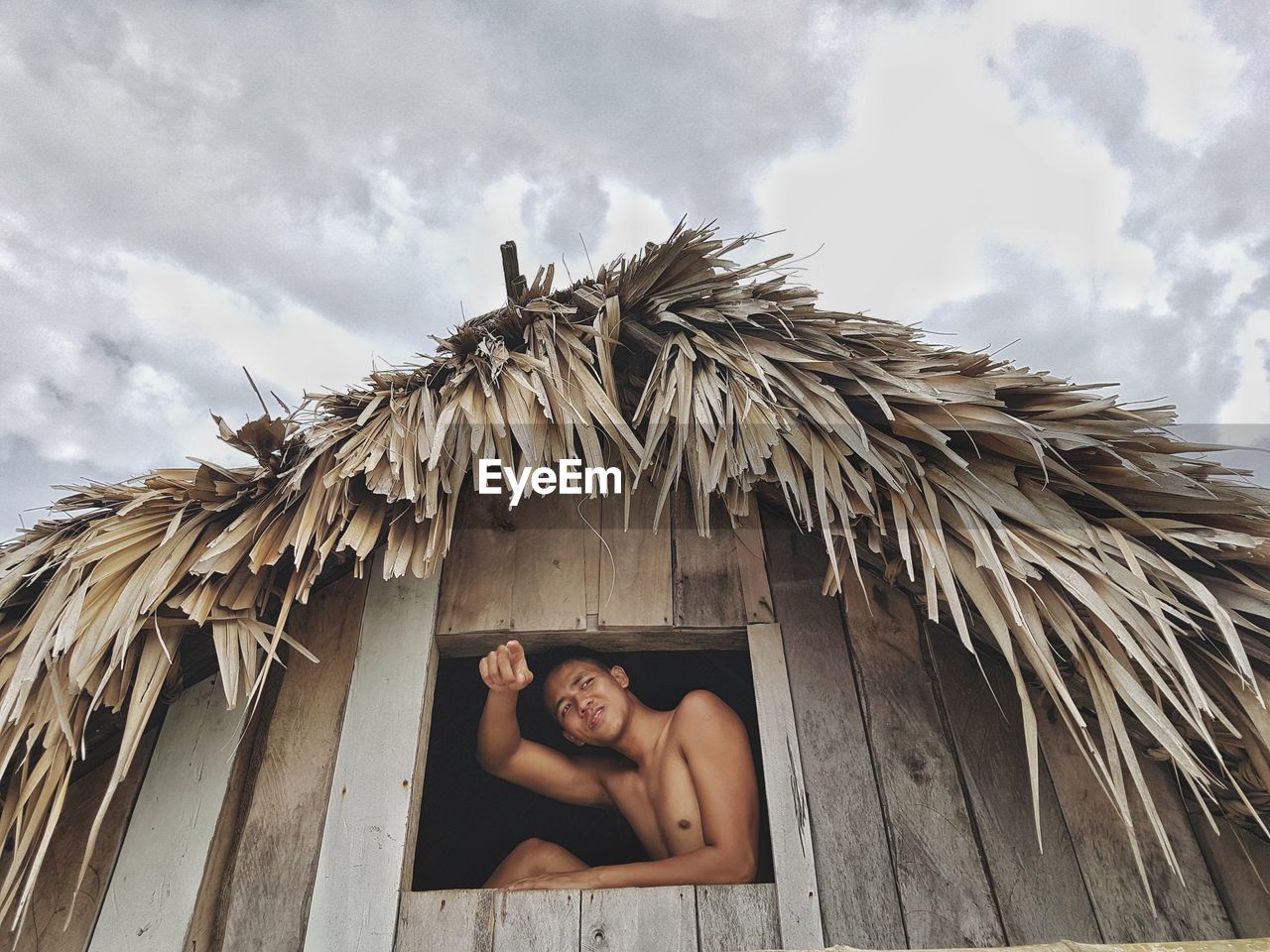 Man sitting at window of hut 