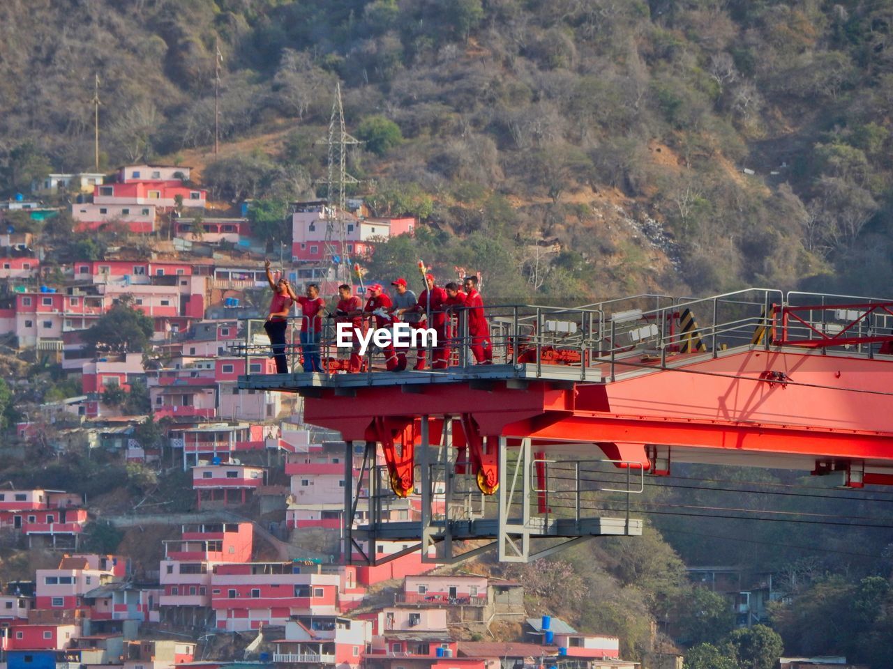 PEOPLE WORKING ON MOUNTAIN AGAINST TREES AND MOUNTAINS