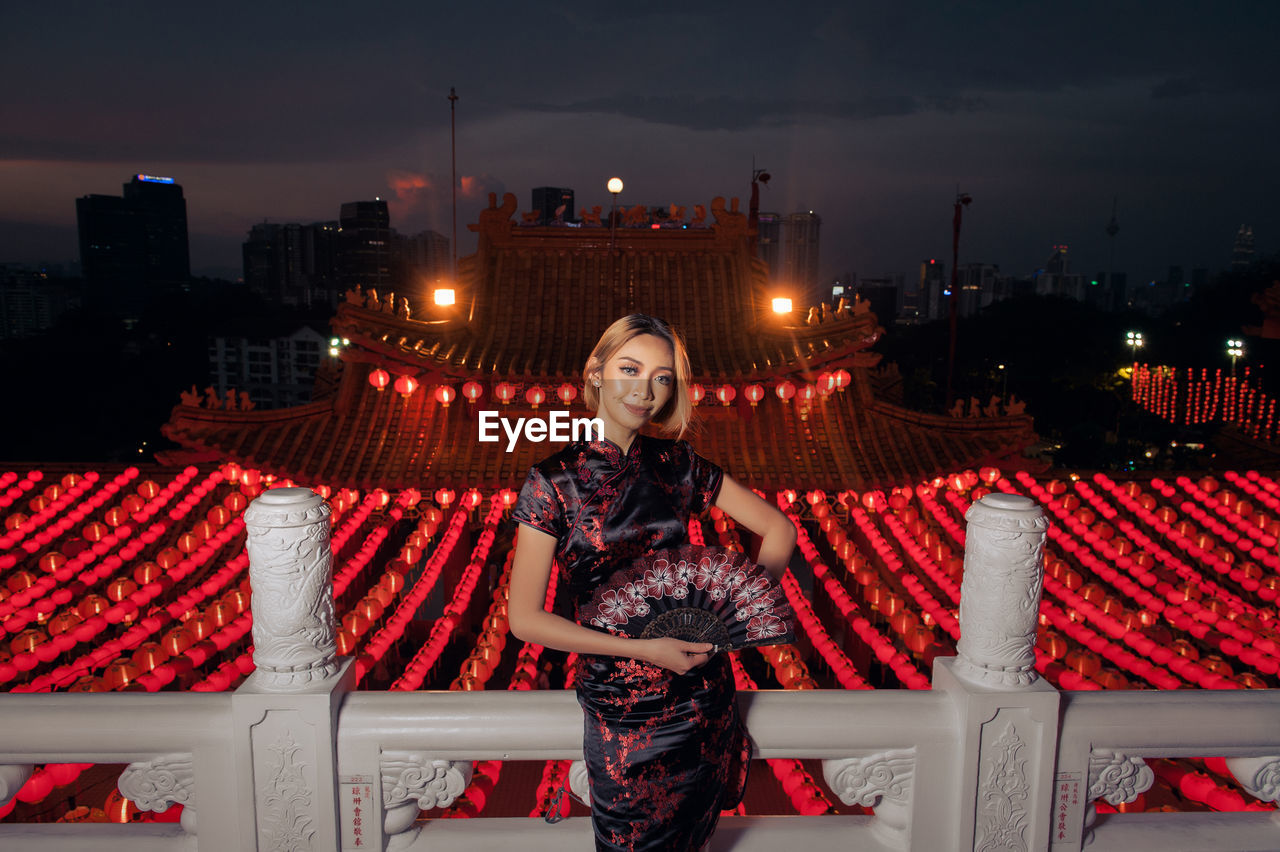 Portrait of young woman in city during chinese lantern festival at night