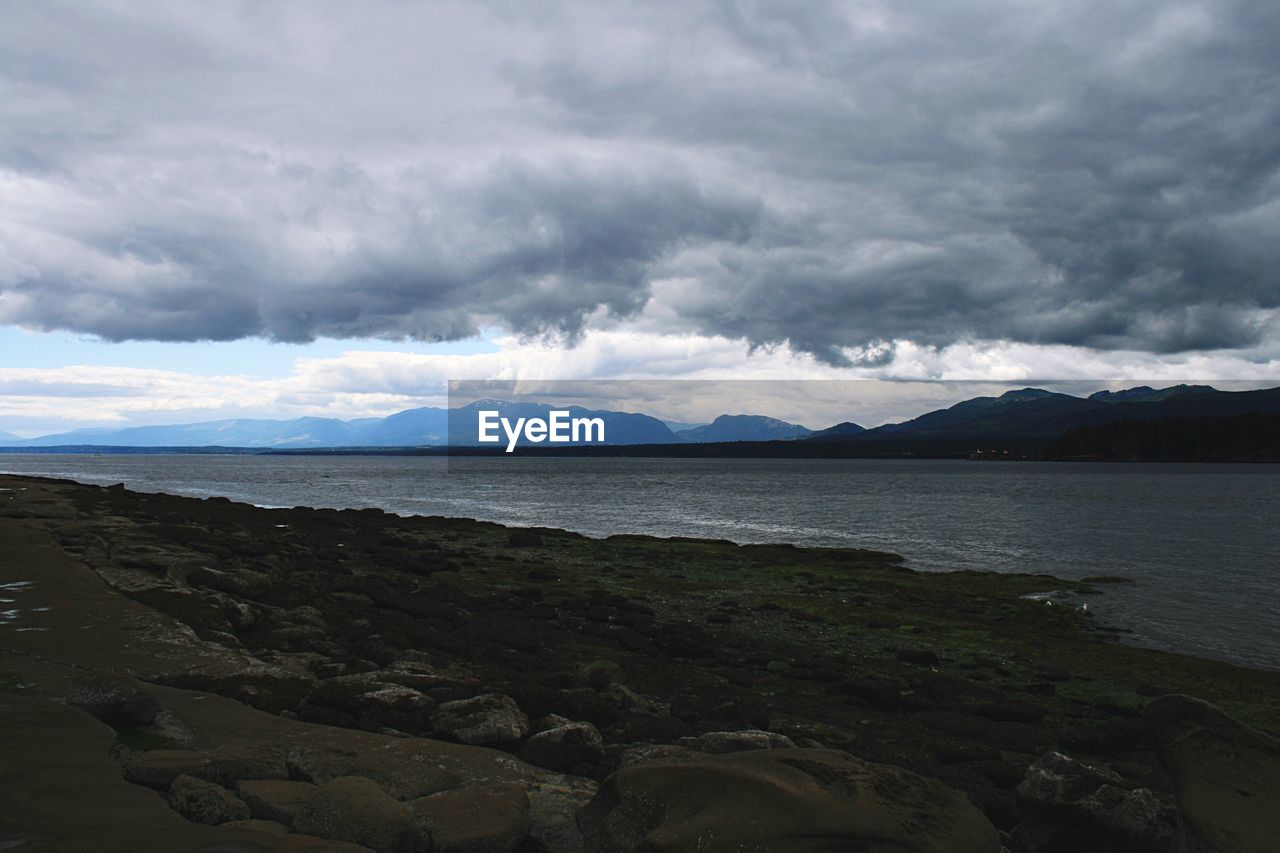 Scenic view of calm sea against cloudy sky