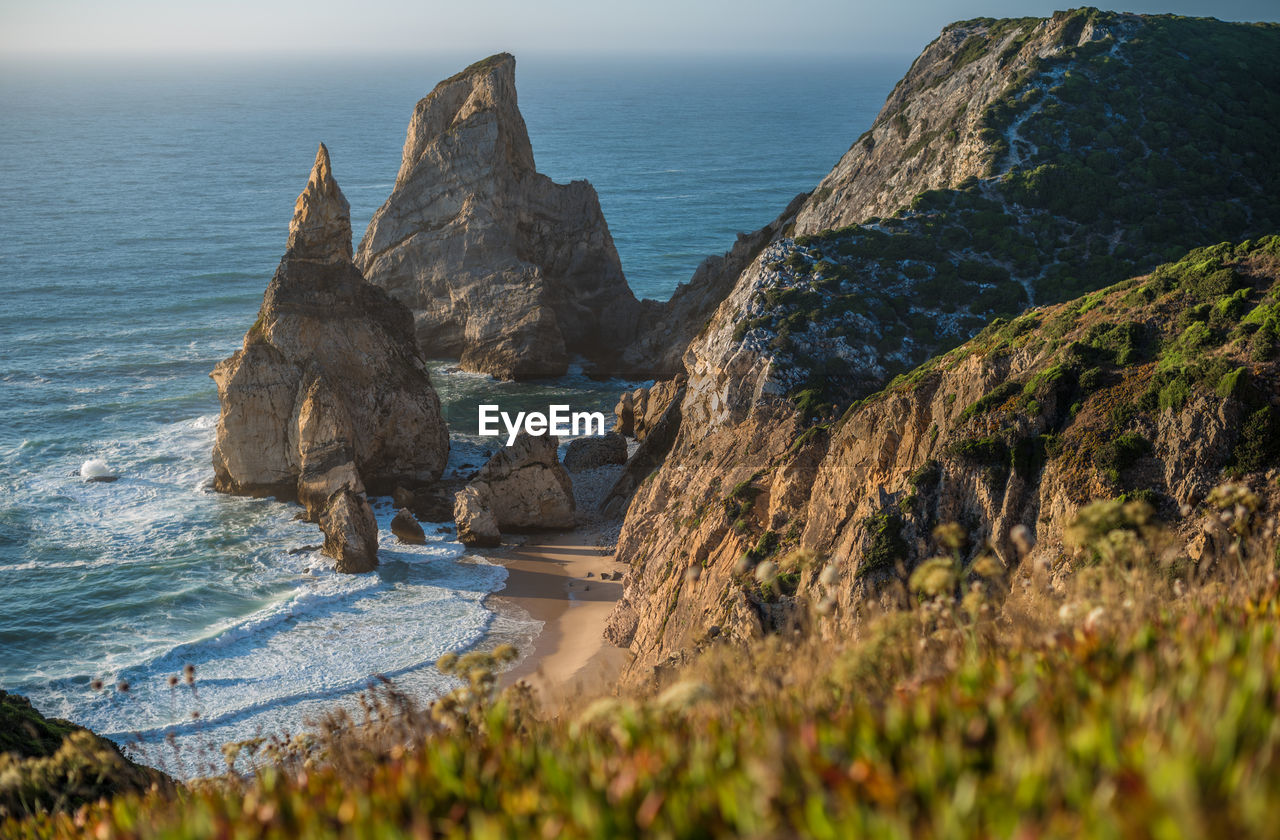 Panoramic view of cliff by sea against sky