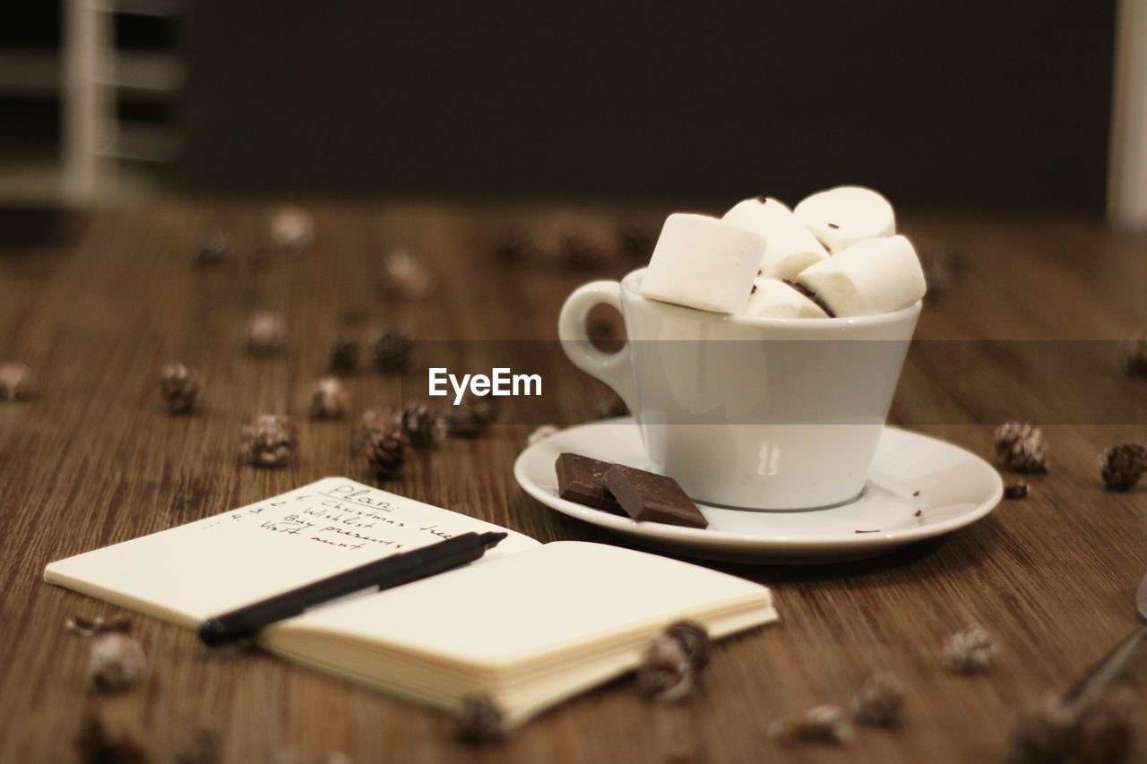 Close-up of coffee cup and planer on table