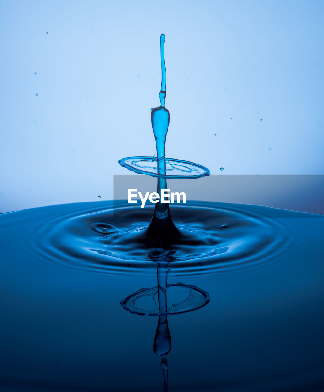 CLOSE-UP OF WATER DROP ON BLUE GLASS