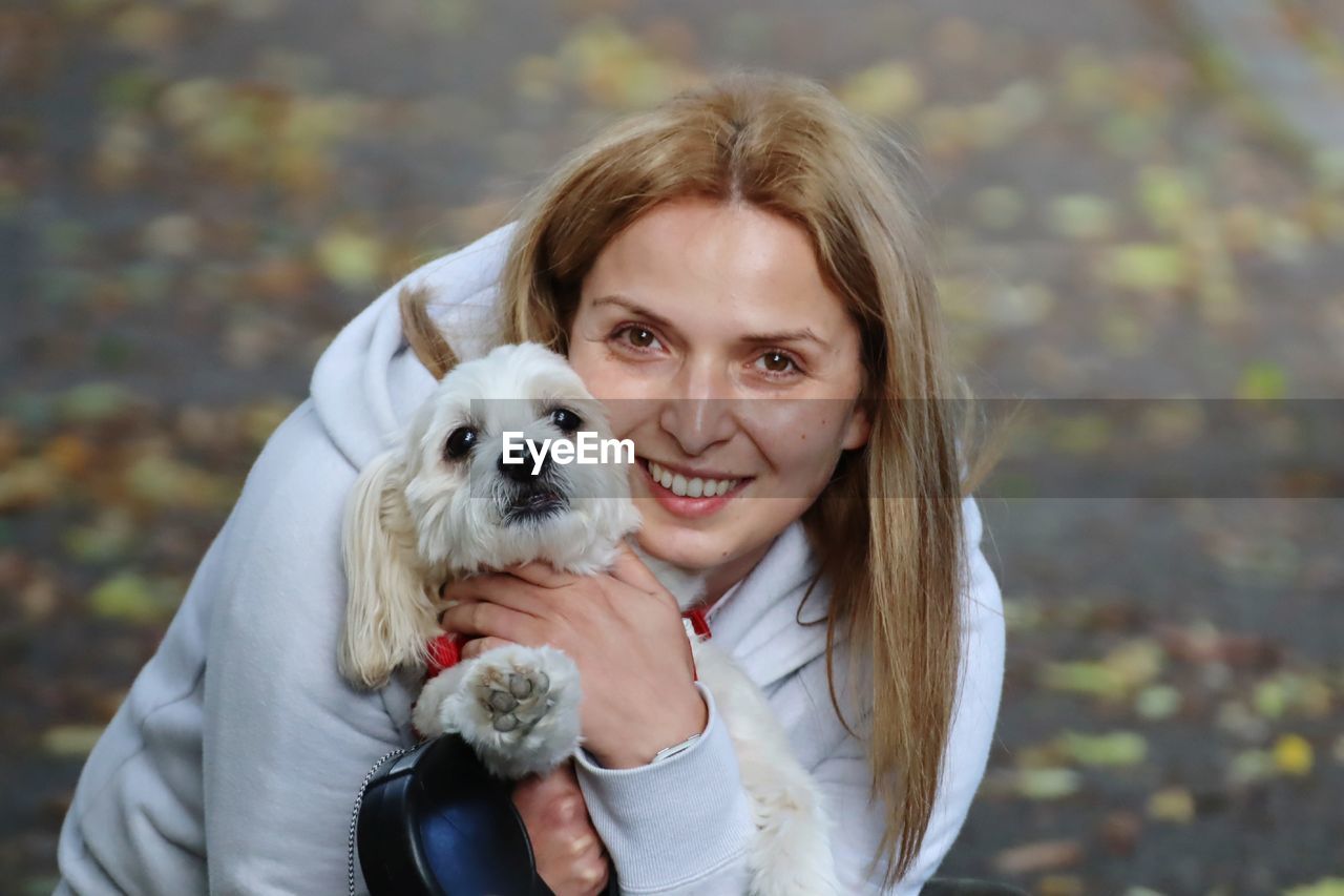 Portrait of smiling woman holding dog