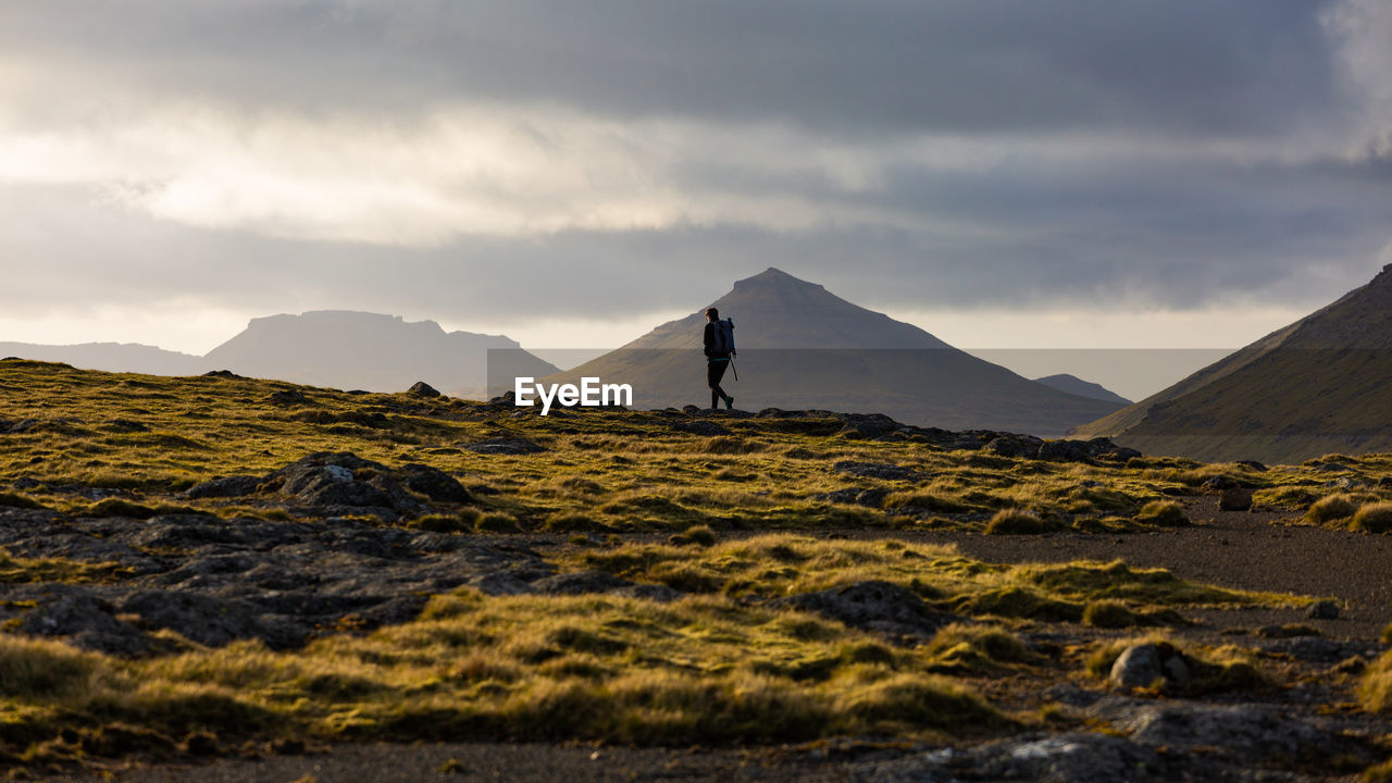 Man standing on mountain against sky during sunset
