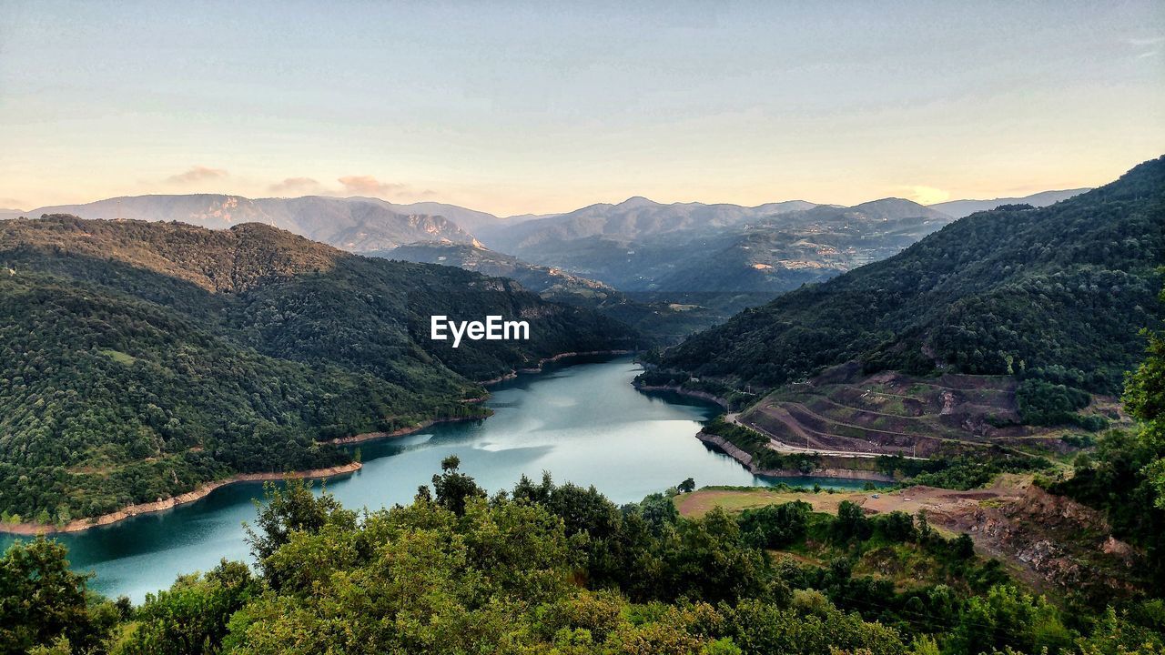 High angle view of lake and mountains against sky