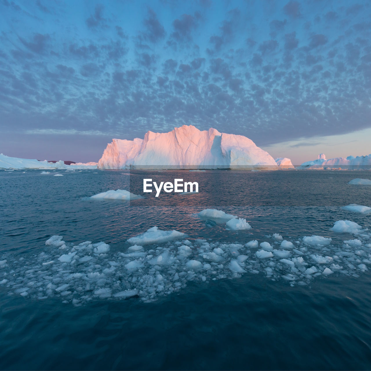 SCENIC VIEW OF FROZEN SEA AGAINST SKY DURING SUNSET