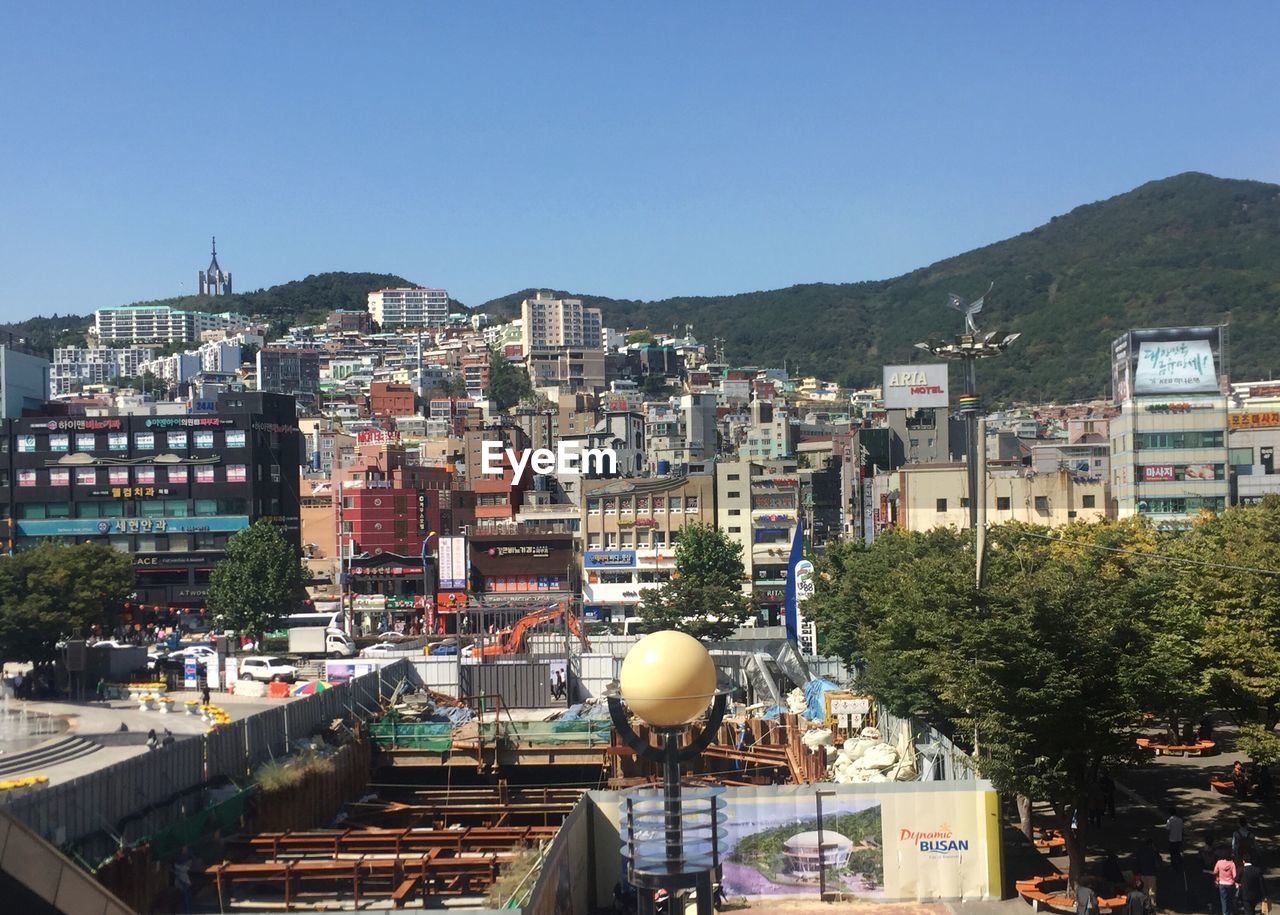 Buildings in city against clear blue sky