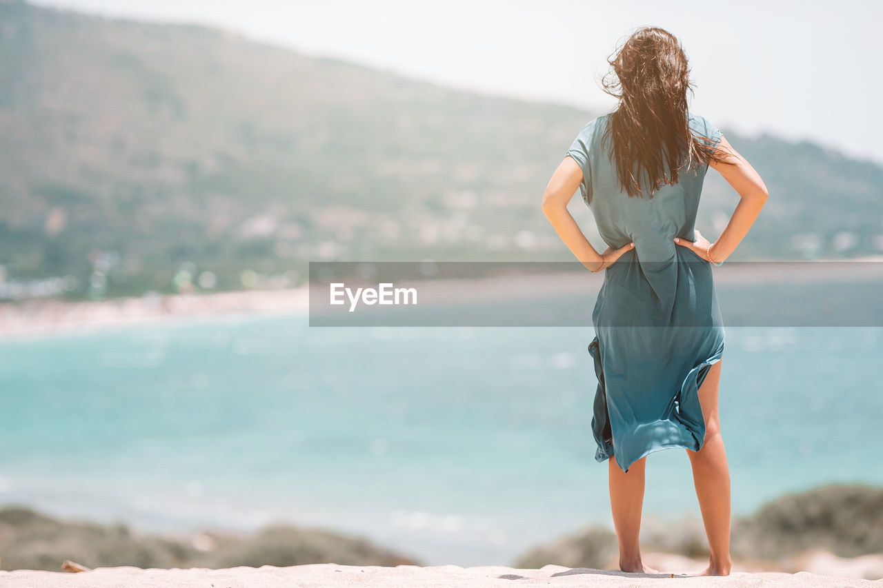 Rear view of woman standing at beach