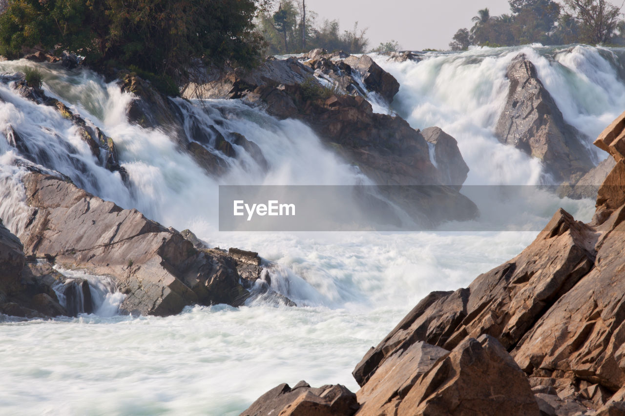 SCENIC VIEW OF WATERFALL AGAINST ROCKS