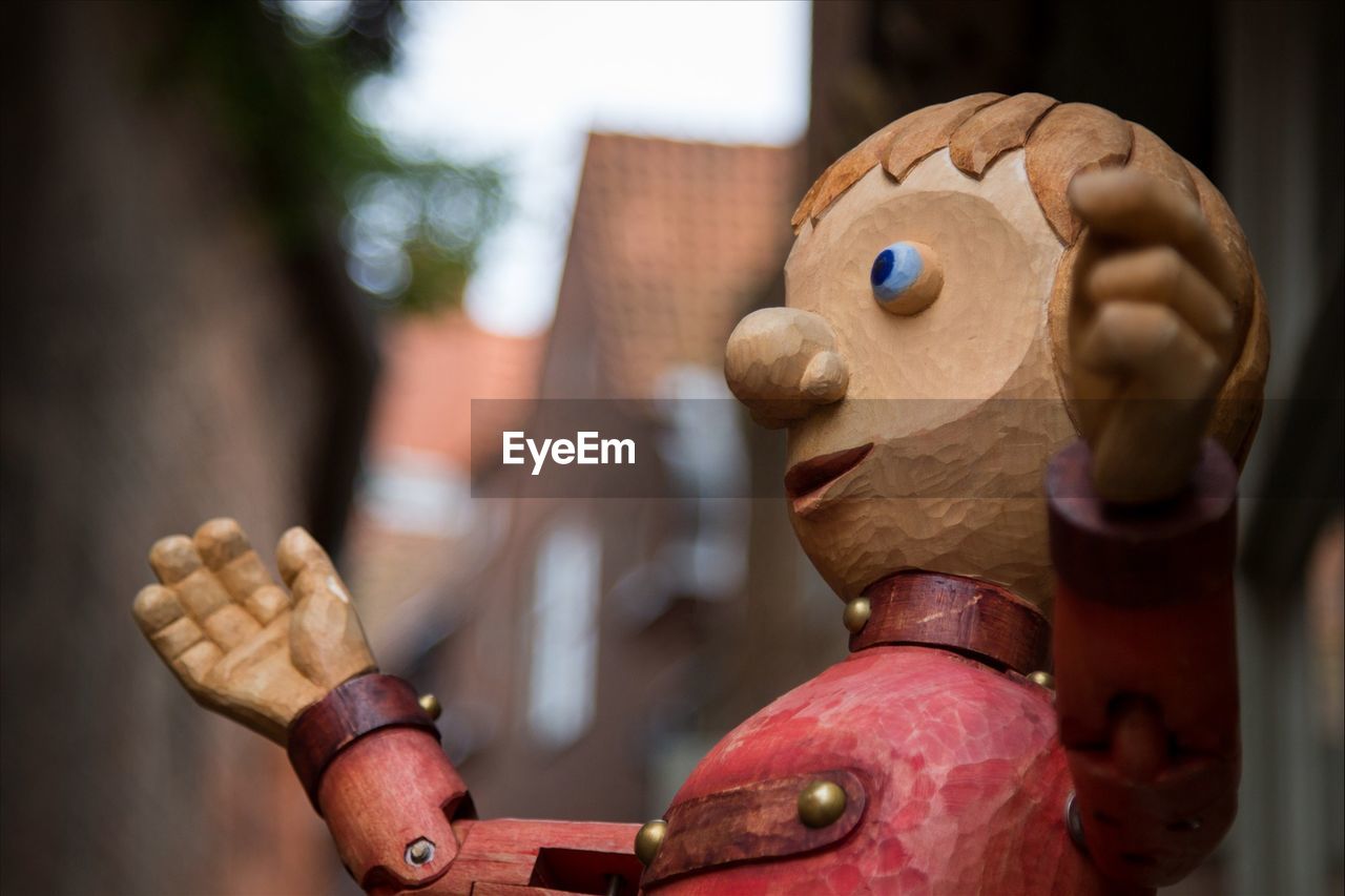 Close-up of wooden toy against houses