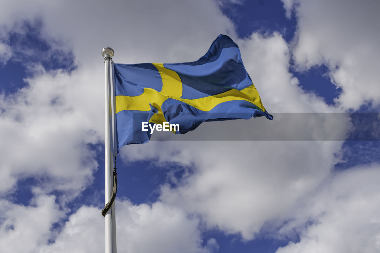 Low angle view of flag against cloudy sky