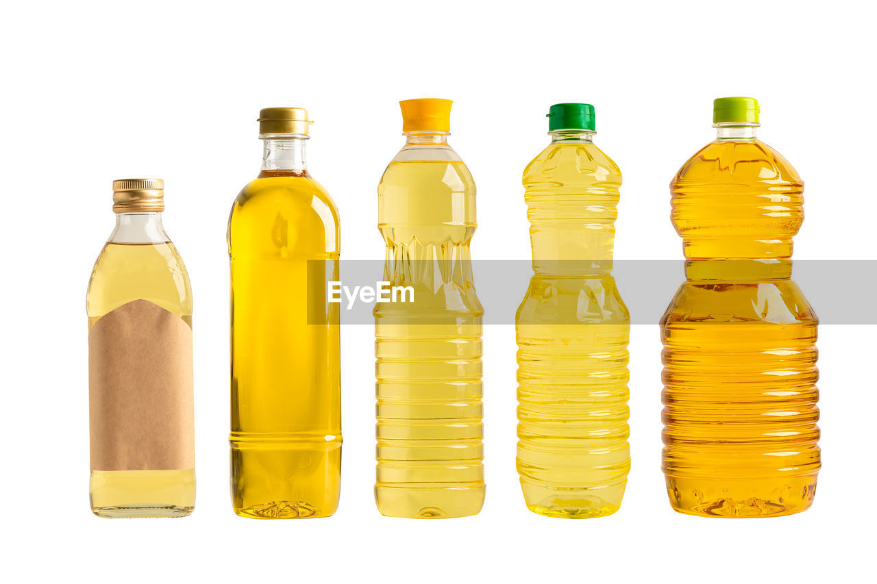 bottle, container, white background, yellow, glass bottle, cut out, studio shot, plastic bottle, drinkware, food and drink, group of objects, in a row, no people, indoors, glass, refreshment