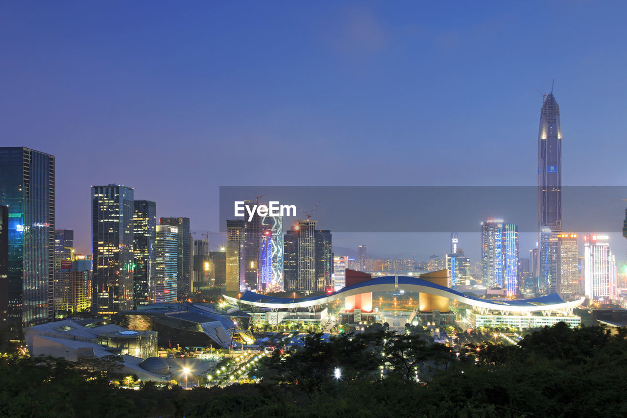 Ping an finance centre with illuminated cityscape against sky at dusk