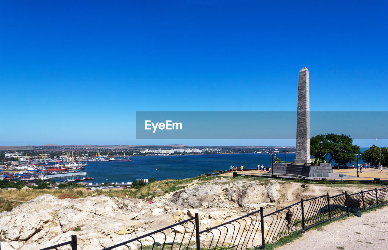 Panoramic view of sea and buildings against clear blue sky