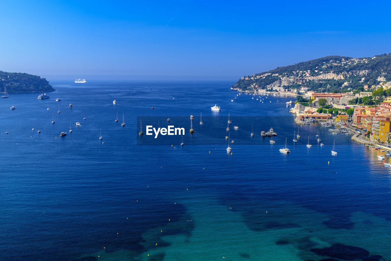 HIGH ANGLE VIEW OF SEA AND CITY AGAINST SKY