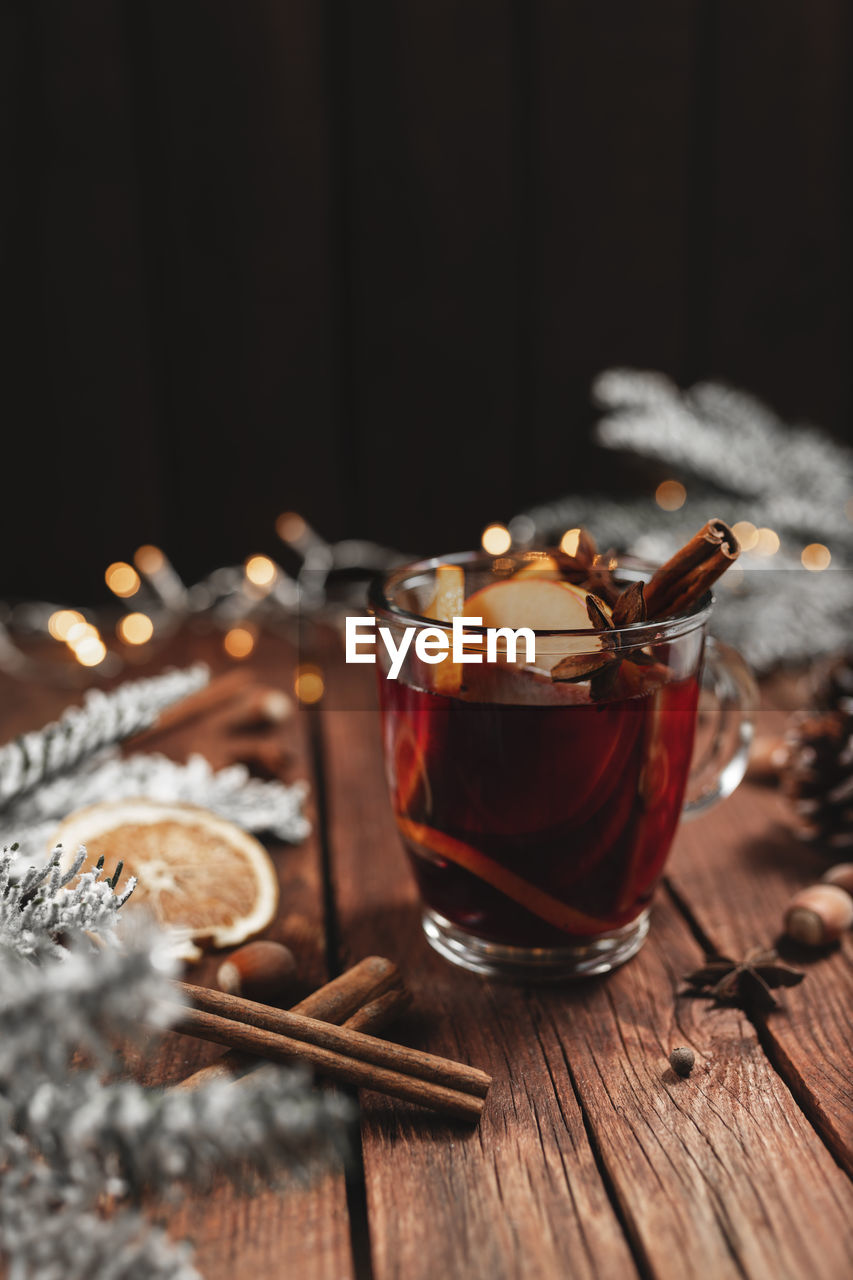 Christmas time concept photo. glass cup or mug with mulled wine inside on wooden table background