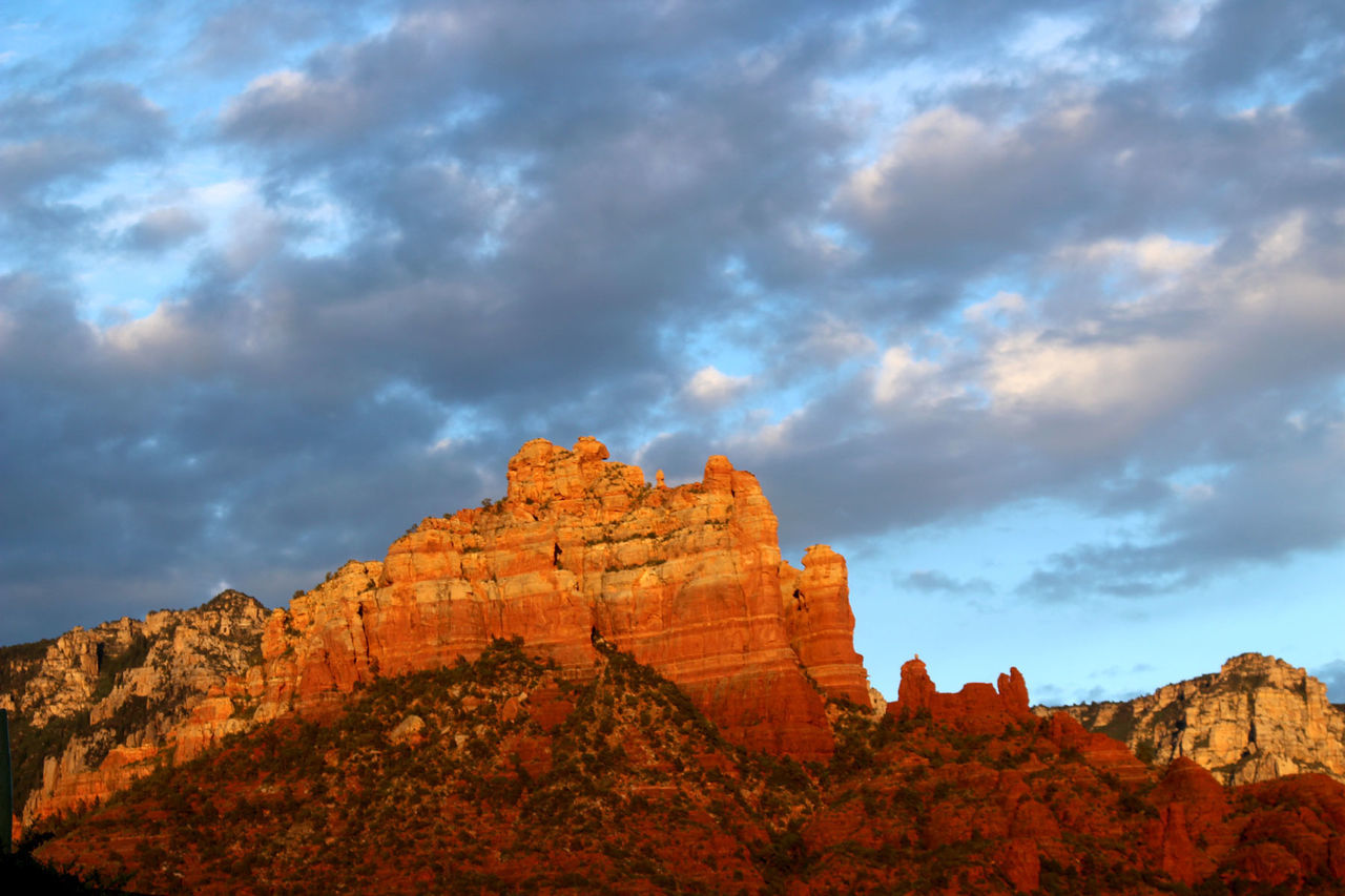 View of rocky cliff against cloudy sky