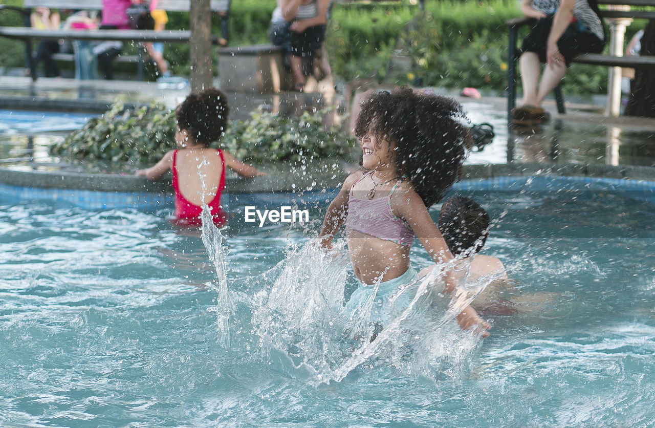 Cheerful girl jumping in swimming pool