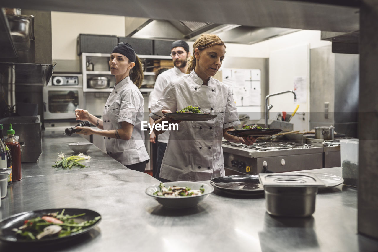 Female and male chefs working in commercial kitchen