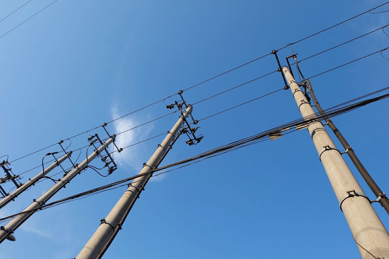 Low angle view of power lines against blue sky on sunny day