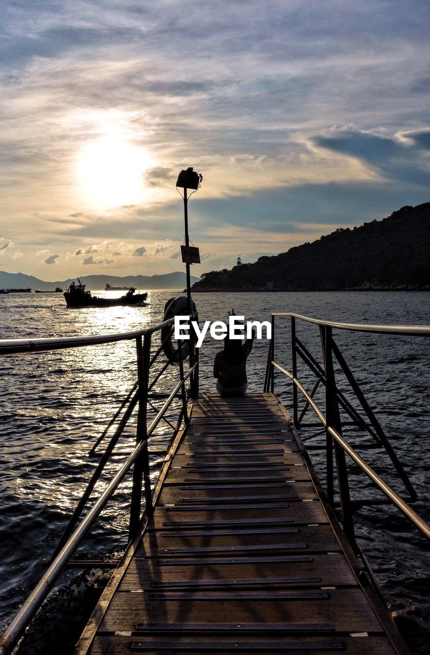 Pier on sea at sunset