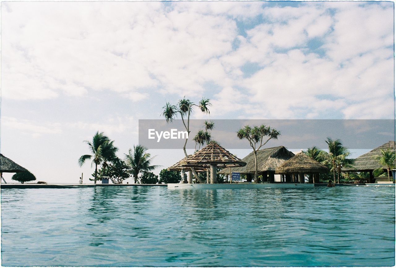 HOUSE BY SWIMMING POOL AGAINST SKY