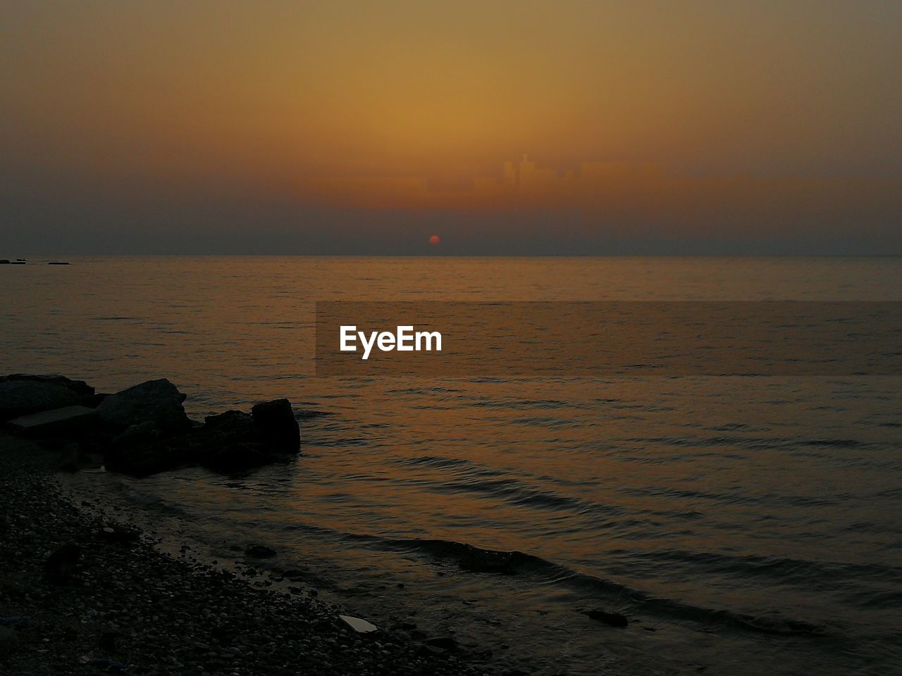 SCENIC VIEW OF SEA AGAINST ORANGE SKY