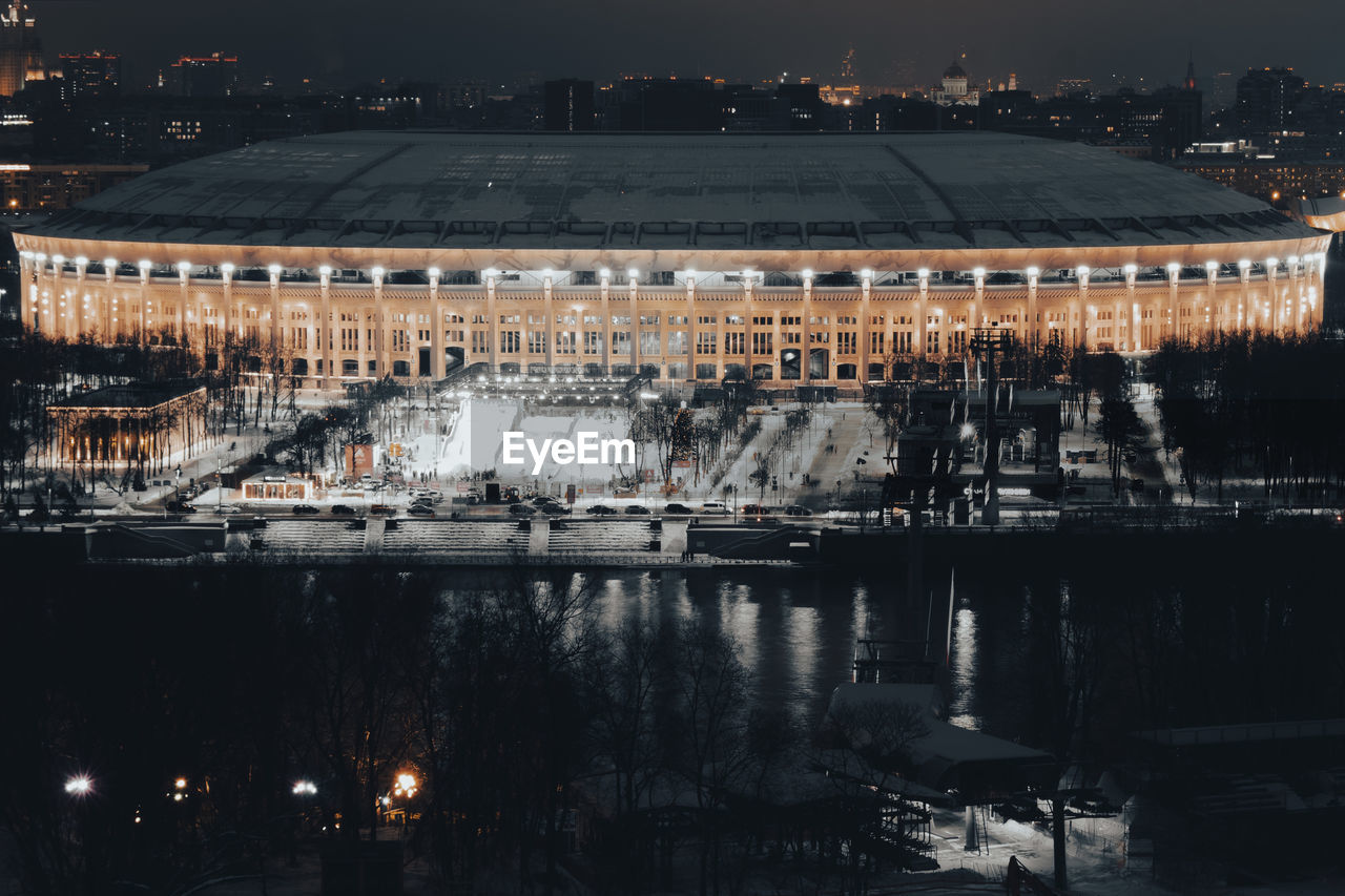 architecture, reflection, built structure, cityscape, building exterior, night, water, city, stadium, skyline, sport venue, evening, nature, no people, urban area, travel destinations, building, high angle view, river, illuminated, sky, outdoors, aerial photography, transportation, travel