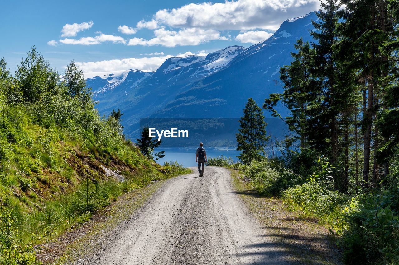 Man walking on road against mountains