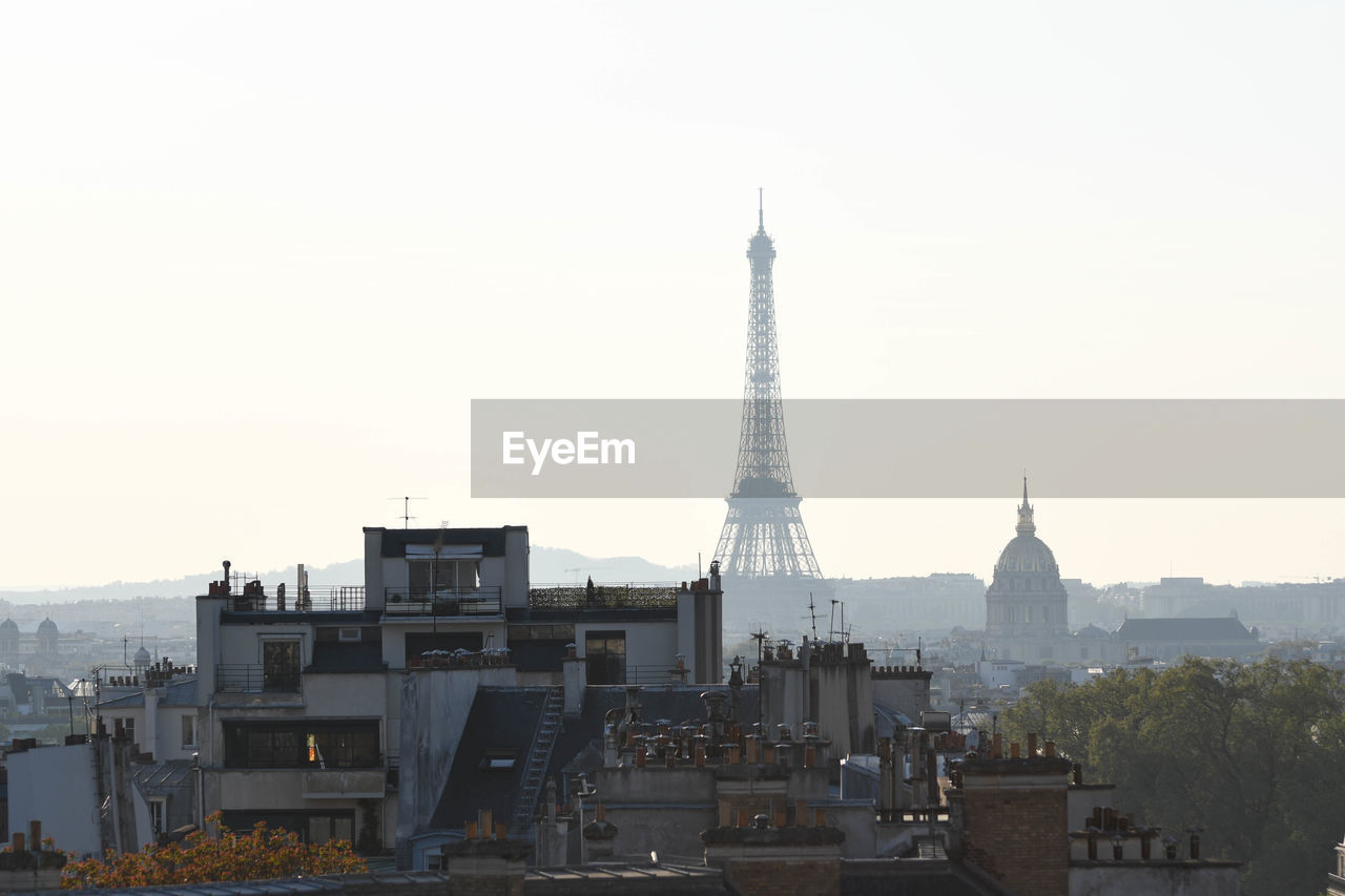 Eiffel tower and buildings against clear sky in city