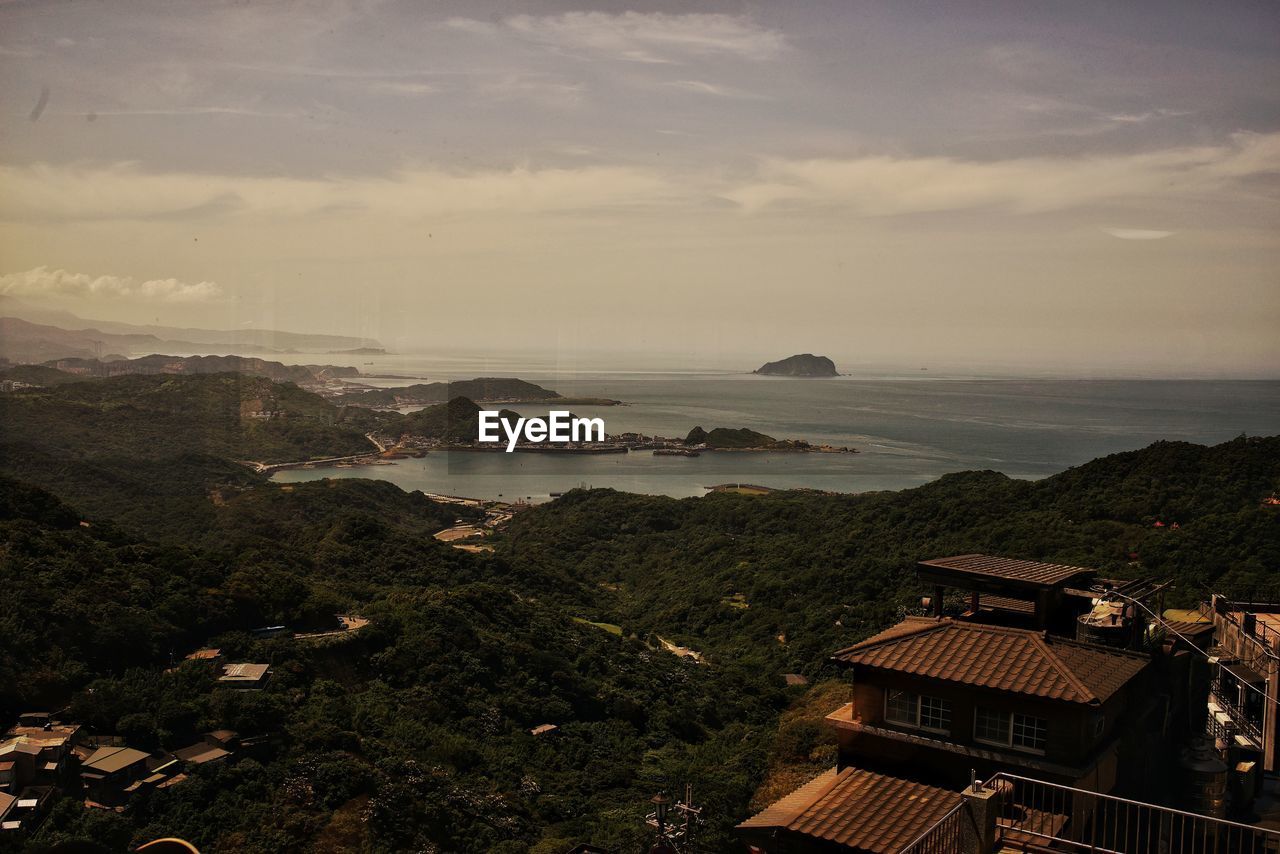 High angle view of buildings by sea against sky