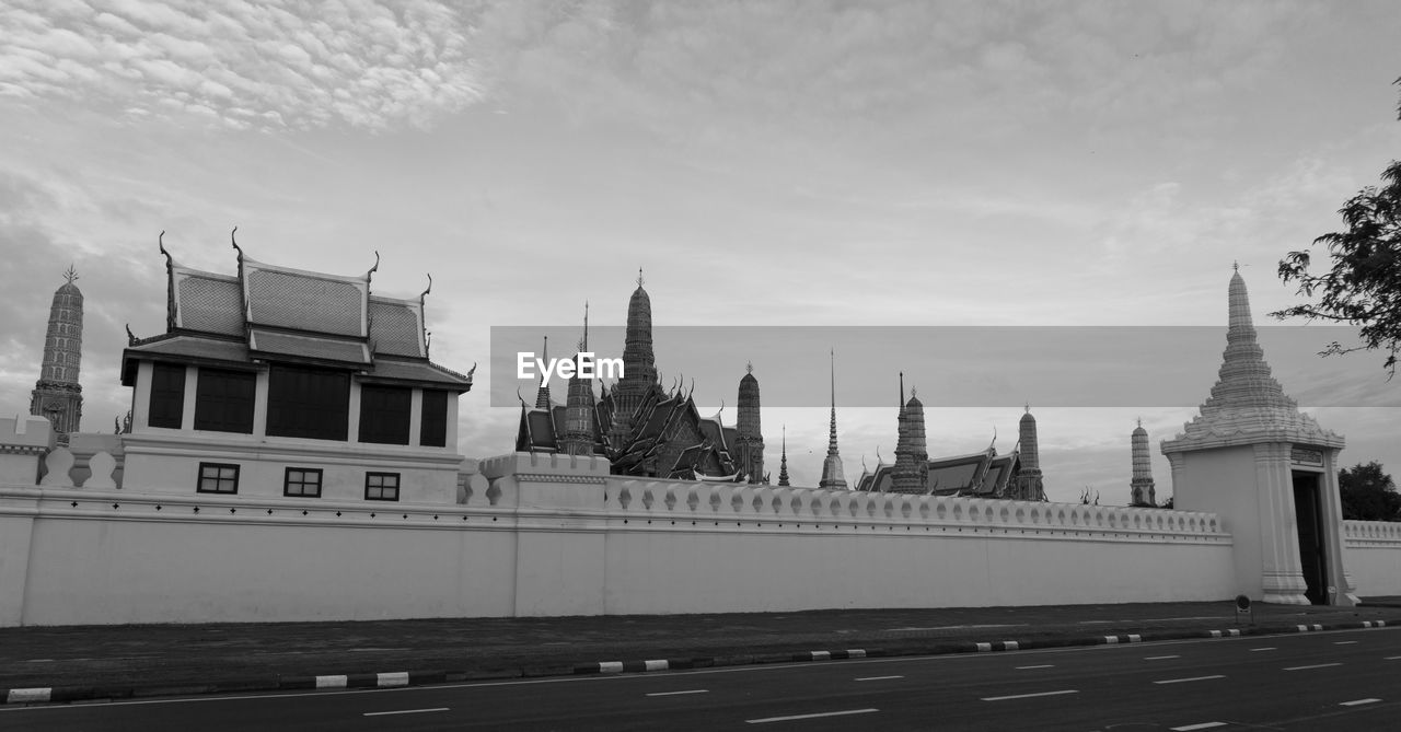 Built structure by river against sky