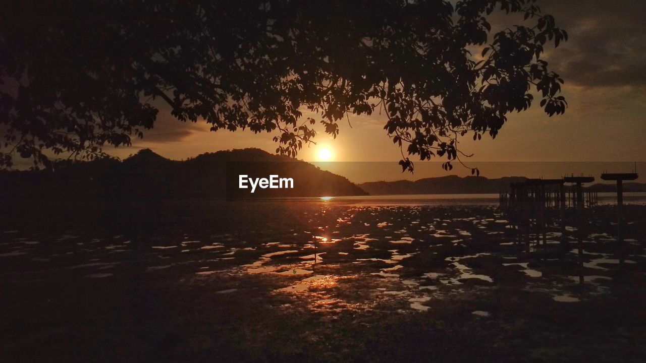 SCENIC VIEW OF LAKE AGAINST SKY AT SUNSET