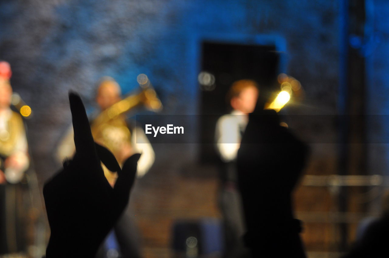 Silhouette cropped hands during music concert