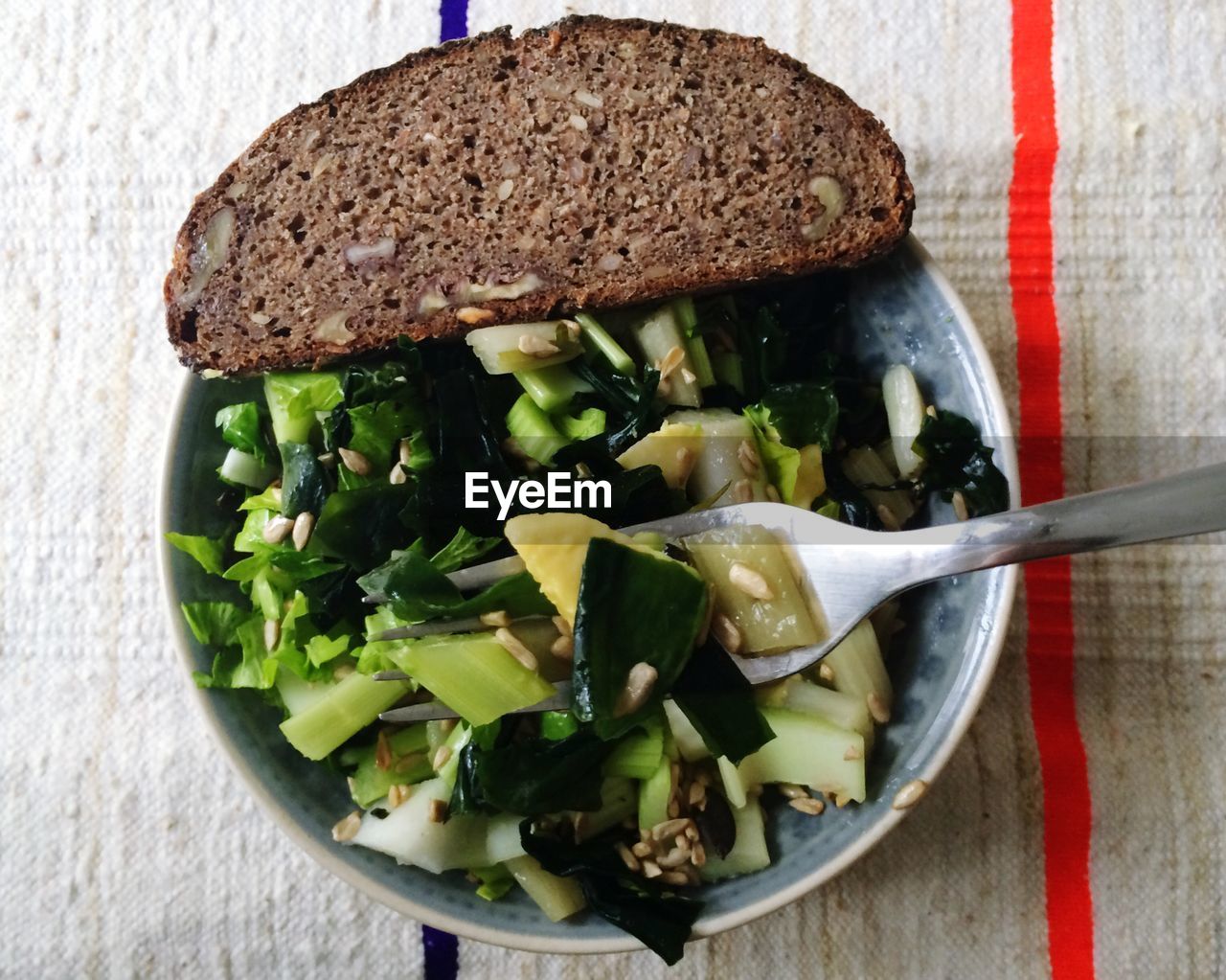 Directly above shot of salad and bread served in bowl on table