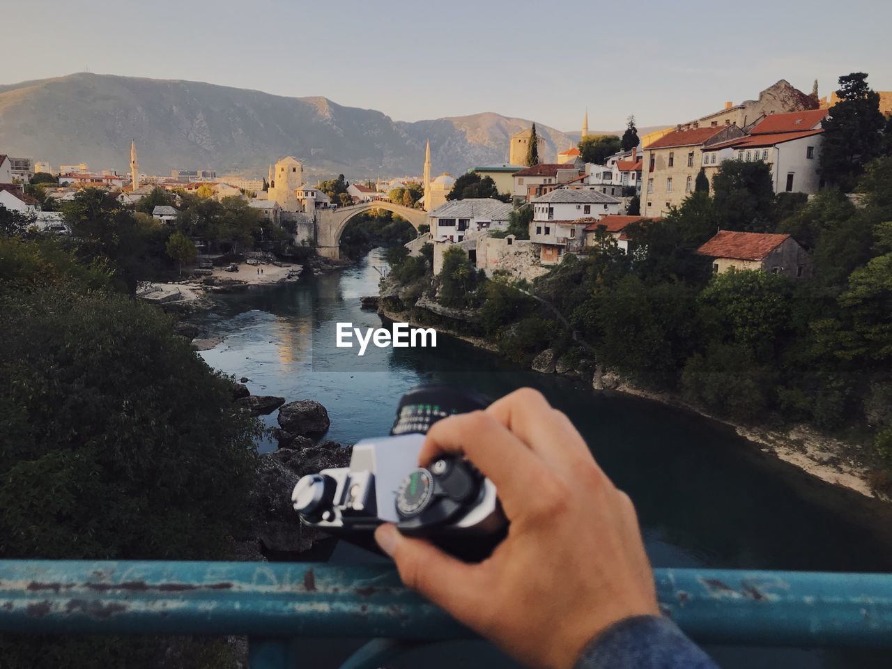 CLOSE-UP OF HAND HOLDING WATER BY RIVER