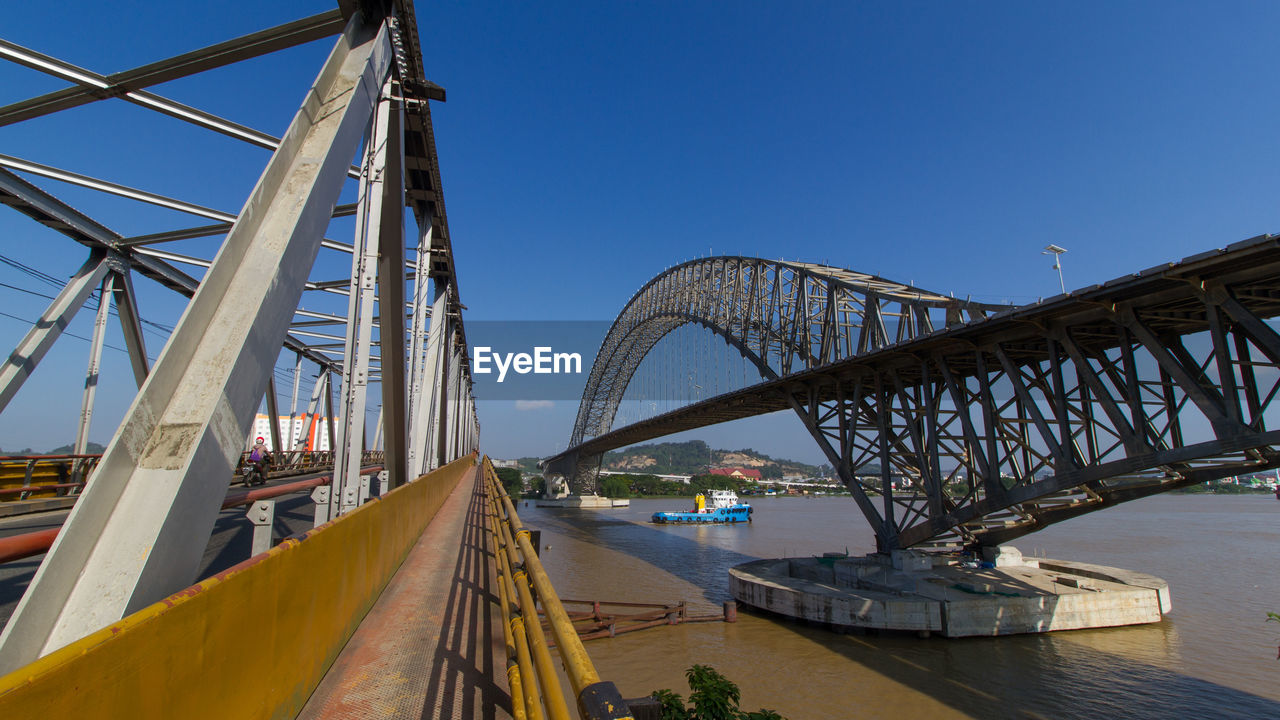 Low angle view of bridge over river against blue sky. makaham river bridge, samarinda